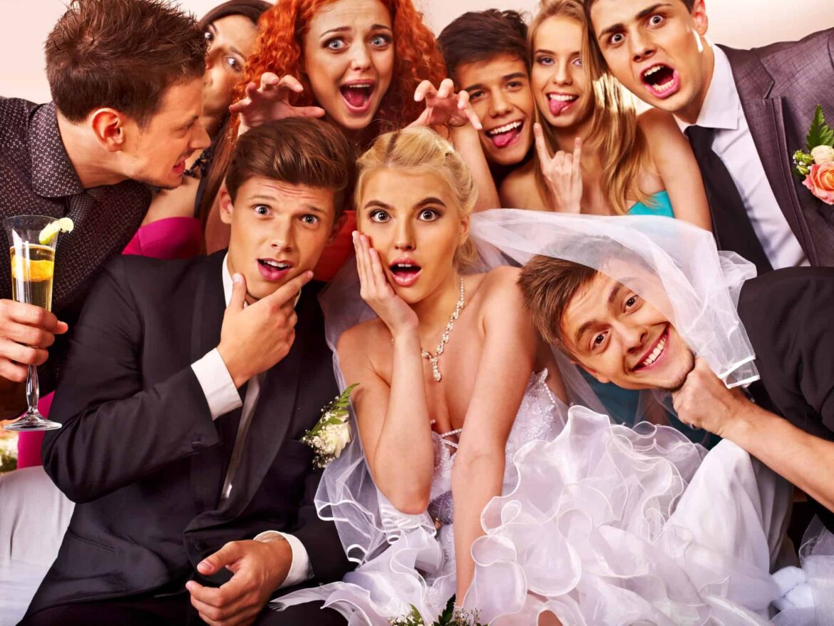 A group of people posing for a photo booth picture at a wedding.