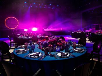 A room with tables and chairs set up for a party that highlights the benefits of renting a photo booth for a corporate event.